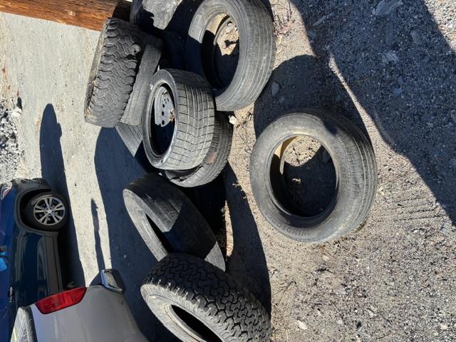 A pile of illegally dumped tires on a dirt lot